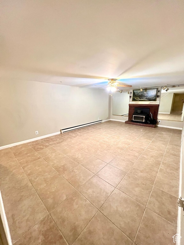 interior space with ceiling fan, a baseboard radiator, light tile patterned floors, and baseboards