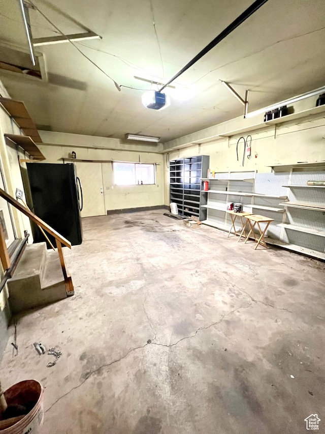 garage with freestanding refrigerator and a garage door opener