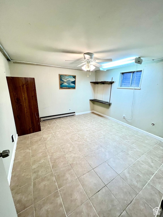 spare room featuring a baseboard heating unit, baseboards, a ceiling fan, and light tile patterned floors