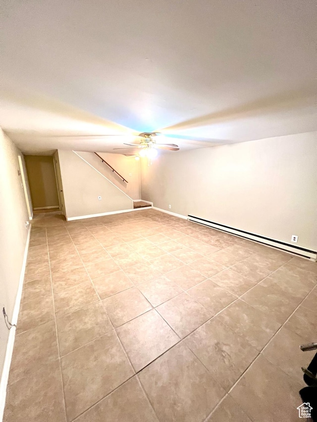 spare room featuring a baseboard radiator, a ceiling fan, light tile patterned flooring, and baseboards