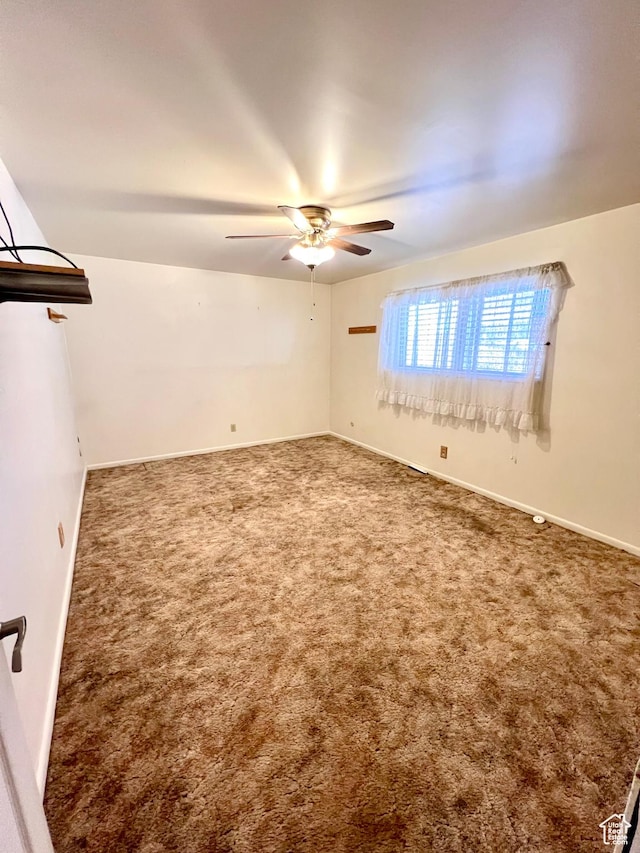 unfurnished room featuring baseboards, a ceiling fan, and carpet
