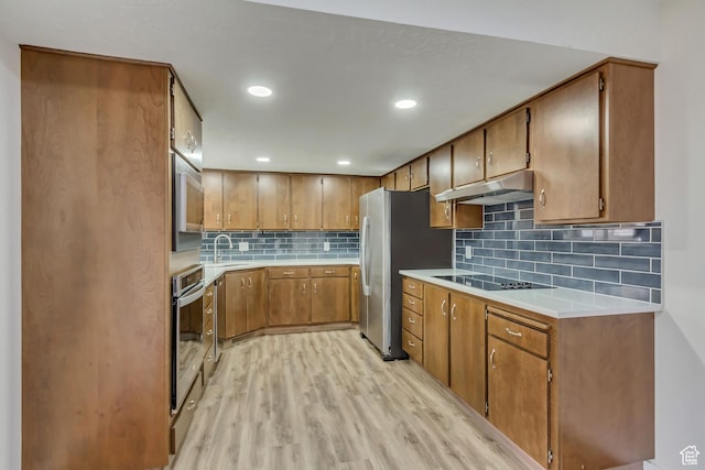 980 Hudson St, Ogden, UT 84404 - kitchen with light wood-type flooring, under cabinet range hood, appliances with stainless steel finishes, light countertops, and a sink