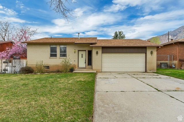 single story home with a garage, a front yard, brick siding, and driveway
