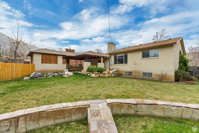 980 Hudson St, Ogden, UT 84404 - rear view of house with a chimney, a yard, fence, and brick siding