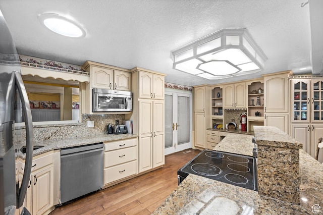 146 W 400 S, Tooele, UT 84074 - kitchen with cream cabinetry, backsplash, appliances with stainless steel finishes, and wood finished floors