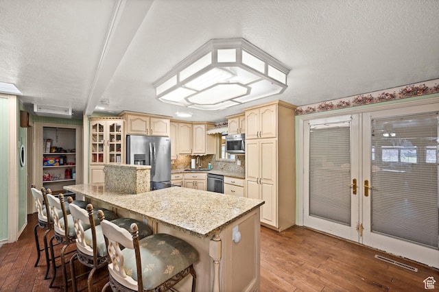 146 W 400 S, Tooele, UT 84074 - kitchen featuring a textured ceiling, a kitchen breakfast bar, hardwood / wood-style flooring, and stainless steel appliances