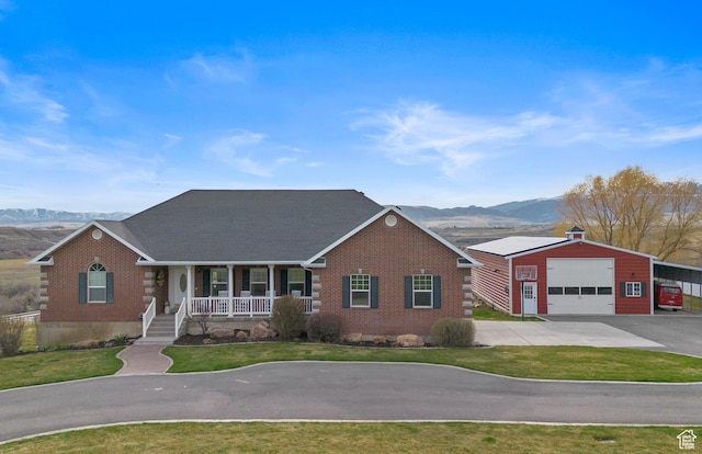 106 N Bear River Blfs, Preston, ID 83263 - view of front of home with covered porch, driveway, a mountain view, and an outbuilding