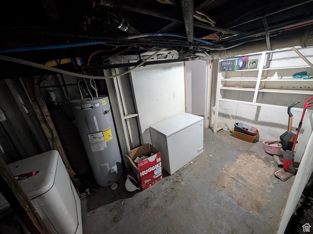 unfinished below grade area featuring refrigerator, electric water heater, and washer / dryer