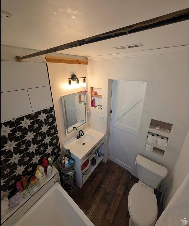 full bathroom featuring visible vents, walk in shower, toilet, vanity, and wood finished floors