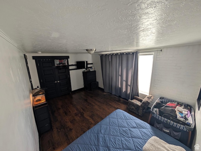 bedroom with a textured ceiling and wood finished floors