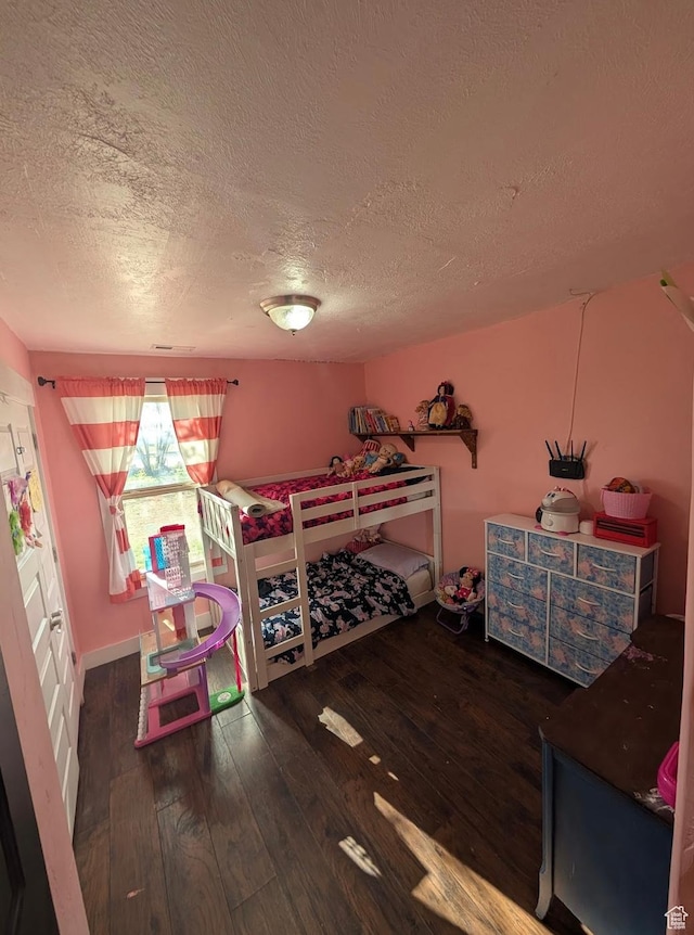 bedroom with wood-type flooring and a textured ceiling