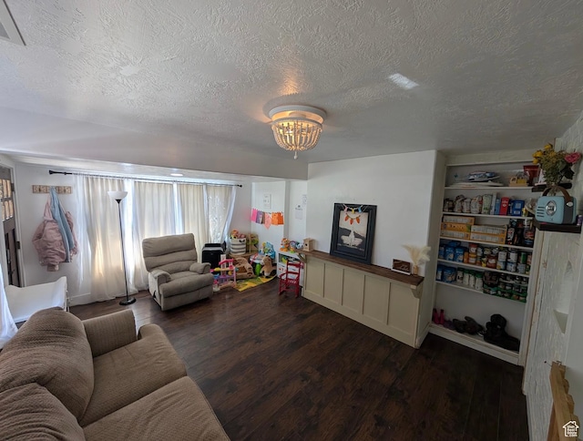 living room featuring a notable chandelier, wood finished floors, and a textured ceiling