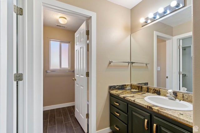 bathroom with wood tiled floor, vanity, baseboards, and visible vents