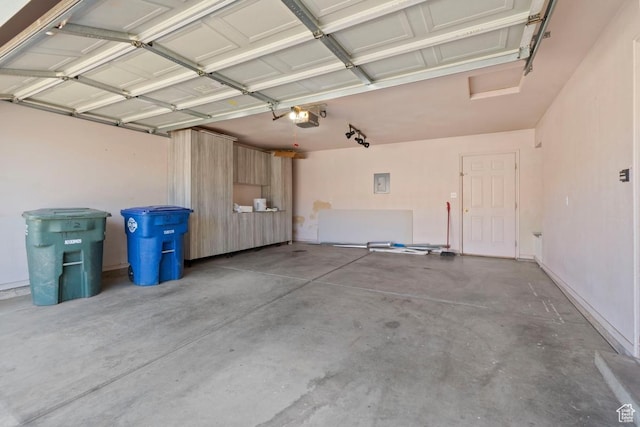 garage with a garage door opener and electric panel