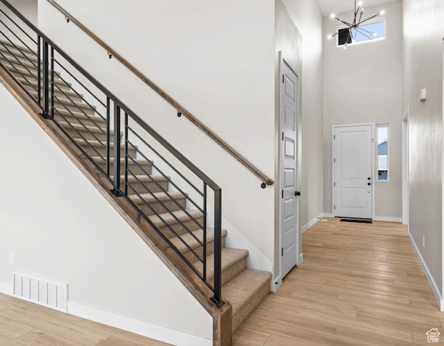 199 N Mia Cv E Unit 12, Saratoga Springs, UT 84045 - entryway featuring baseboards, a towering ceiling, a chandelier, stairway, and light wood-type flooring
