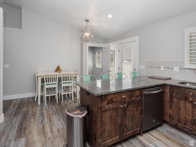 131 Crockett Ave, Logan, UT 84321 - kitchen with dishwasher, wood finished floors, a chandelier, stone counters, and decorative backsplash