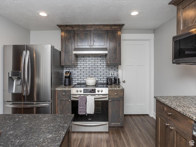 131 Crockett Ave, Logan, UT 84321 - kitchen featuring stainless steel appliances, under cabinet range hood, dark wood-style floors, decorative backsplash, and dark brown cabinetry