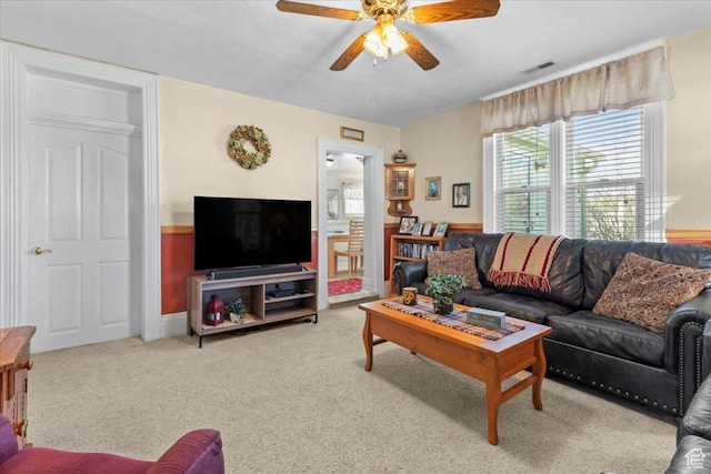 living room with carpet flooring, visible vents, and a ceiling fan