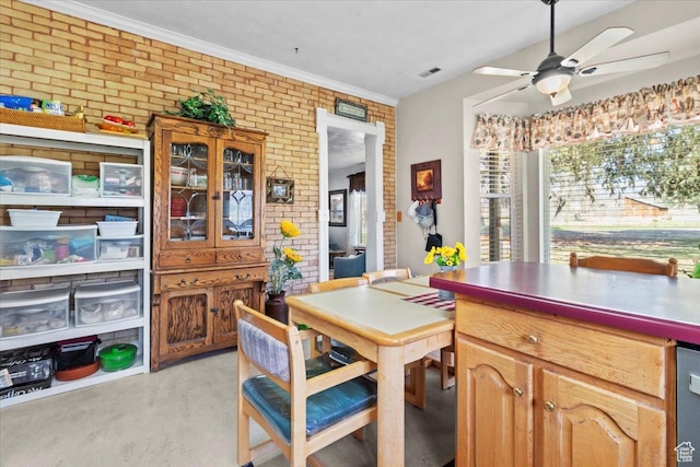 dining room with light wood finished floors, brick wall, ceiling fan, and visible vents
