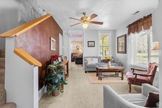 living room with visible vents, ceiling fan, and carpet