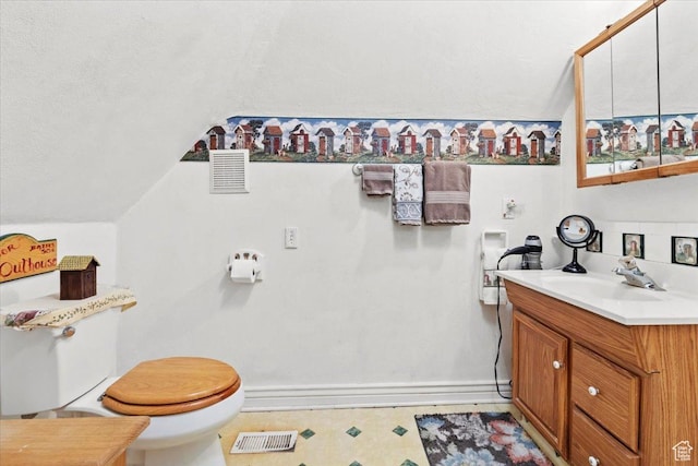 bathroom featuring vanity, vaulted ceiling, visible vents, toilet, and baseboards
