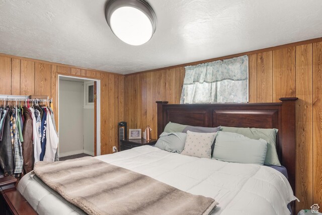 268 S Main St, Malad City, ID 83252 - bedroom with wooden walls, a closet, and a textured ceiling