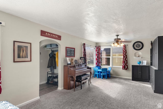 268 S Main St, Malad City, ID 83252 - sitting room with baseboards, a textured ceiling, a ceiling fan, carpet floors, and arched walkways