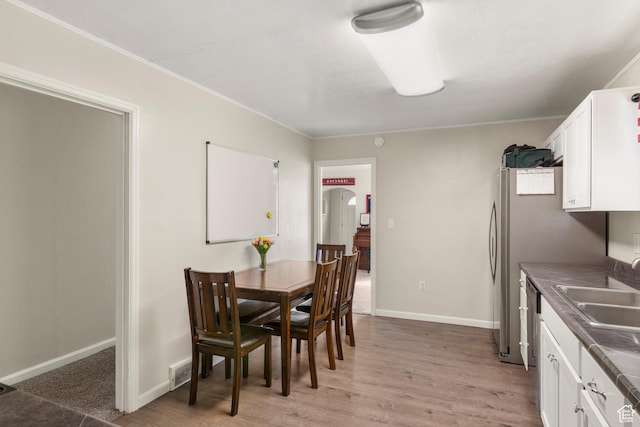 268 S Main St, Malad City, ID 83252 - dining space featuring arched walkways, light wood-style floors, baseboards, and ornamental molding