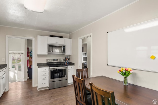 268 S Main St, Malad City, ID 83252 - kitchen with ornamental molding, white cabinets, wood finished floors, dark countertops, and stainless steel appliances