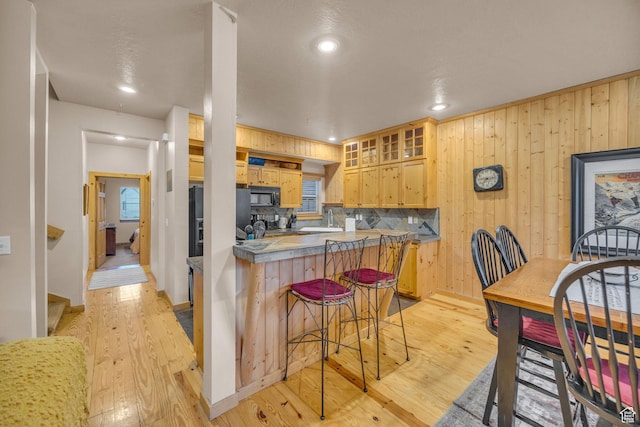 5424 Bobsled Blvd Unit T2, Park City, UT 84098 - kitchen with glass insert cabinets, fridge with ice dispenser, light wood-type flooring, a breakfast bar, and black microwave
