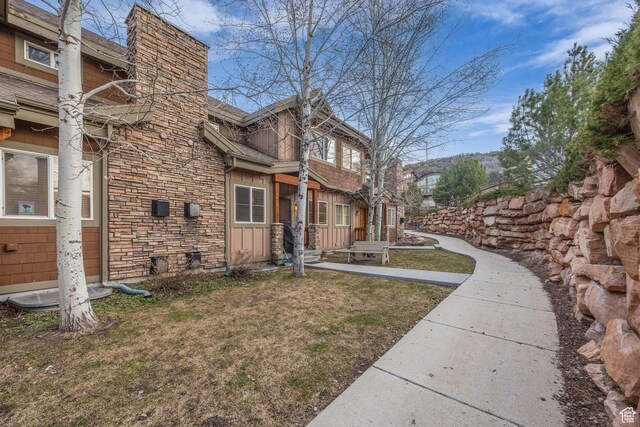 5424 Bobsled Blvd Unit T2, Park City, UT 84098 - view of side of property featuring board and batten siding, stone siding, a lawn, and a chimney