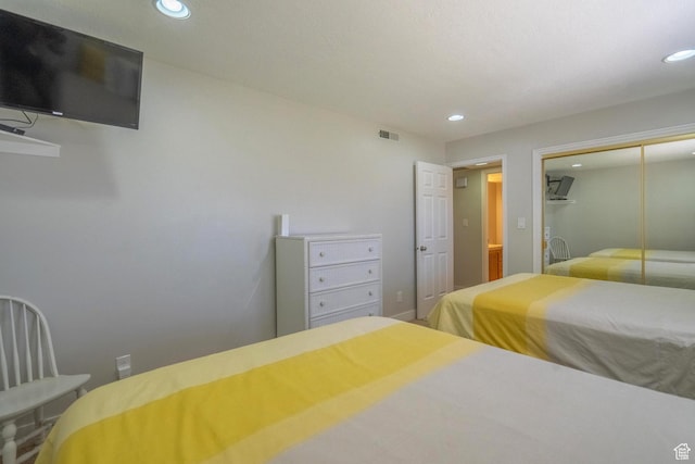 bedroom with a closet, visible vents, and recessed lighting