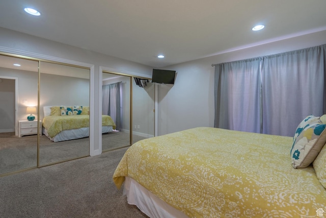 carpeted bedroom with two closets, baseboards, and recessed lighting