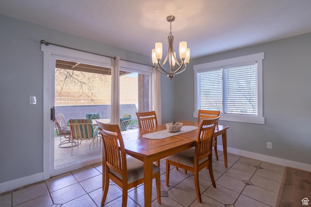 dining room with an inviting chandelier, a healthy amount of sunlight, and baseboards