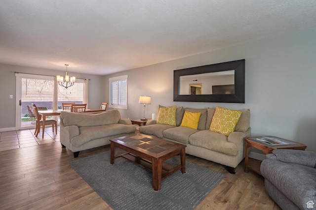 living room featuring a chandelier, wood finished floors, and baseboards