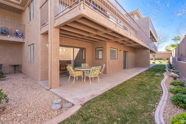 rear view of house with a patio and stucco siding