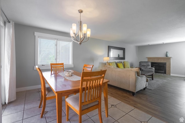 dining area featuring baseboards, a chandelier, and light tile patterned flooring