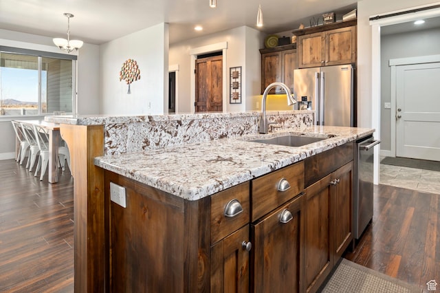 5185 N 600 E, Enoch, UT 84721 - kitchen featuring a sink, appliances with stainless steel finishes, an island with sink, light stone countertops, and dark wood-type flooring