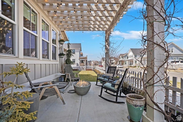 view of patio featuring a residential view, a pergola, and a fire pit