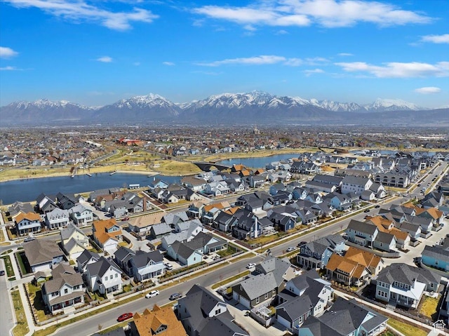 drone / aerial view featuring a water and mountain view and a residential view