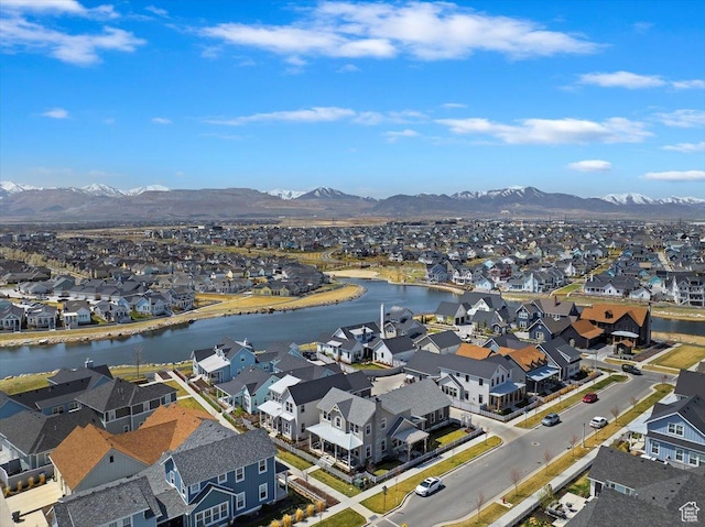 drone / aerial view with a water and mountain view and a residential view