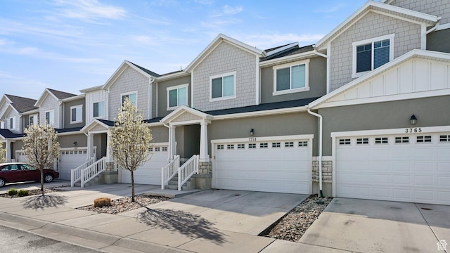 townhome / multi-family property with an attached garage, board and batten siding, driveway, and a residential view