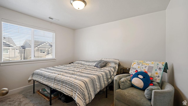 carpeted bedroom featuring visible vents and baseboards