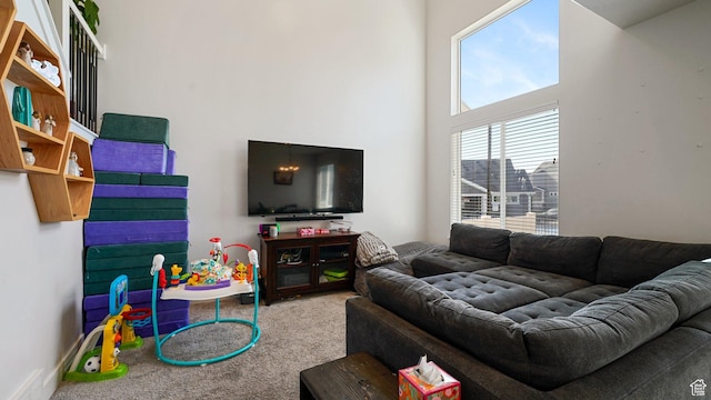 carpeted living room featuring a high ceiling