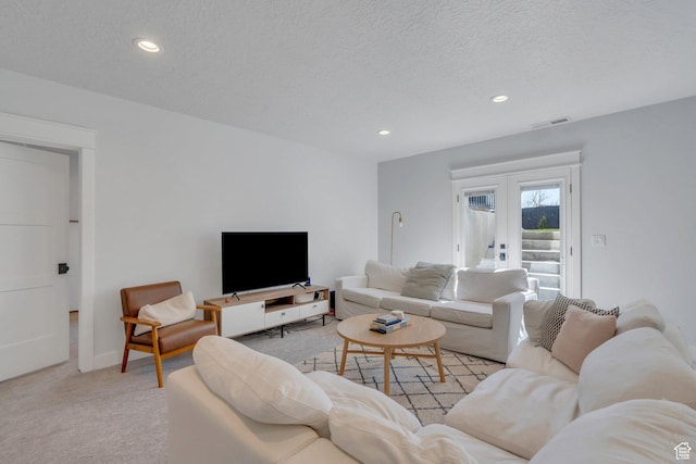 living room with recessed lighting, light carpet, and a textured ceiling