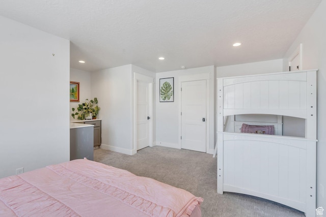 bedroom featuring baseboards, recessed lighting, light colored carpet, and a textured ceiling