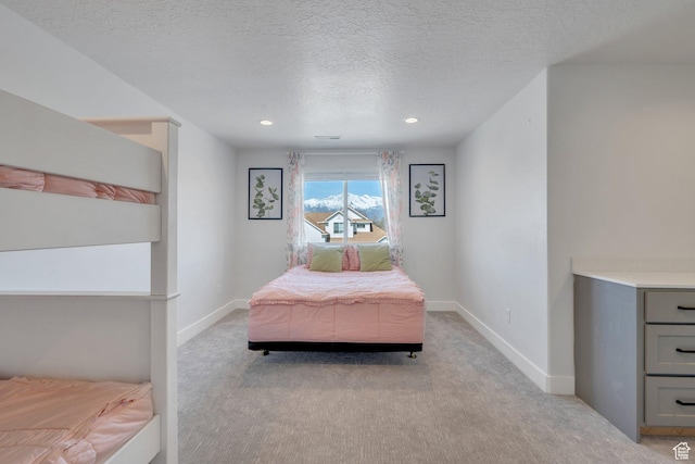 bedroom with light carpet, recessed lighting, baseboards, and a textured ceiling