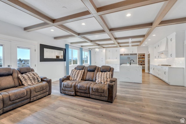 living area with coffered ceiling, light wood-type flooring, beamed ceiling, and baseboards