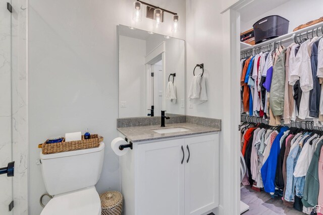 full bath with a spacious closet, toilet, and vanity