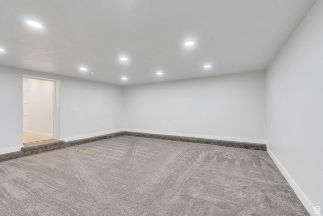 empty room with baseboards, recessed lighting, and carpet